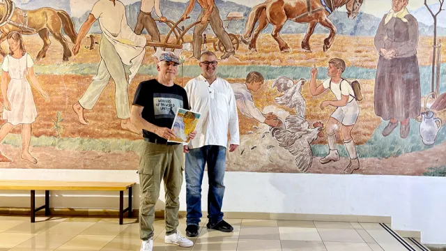 Bruno Schernhammer und Michael Wittig vor dem Fresko von Erwin Lang in der Mittelschule Vorchdorf